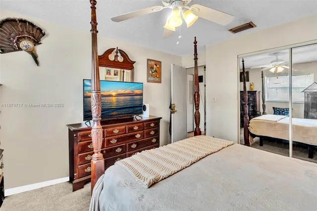a bedroom with a bed and a large mirror on the dresser