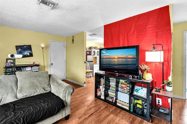 a kitchen with a refrigerator a stove a sink and white cabinets with wooden floor