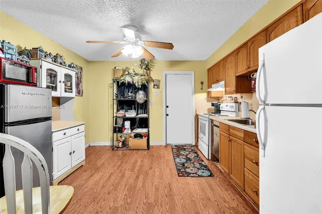 a kitchen with a sink a refrigerator and cabinets
