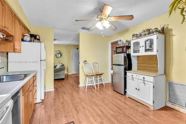 a view of a hallway view with wooden floor and a living room