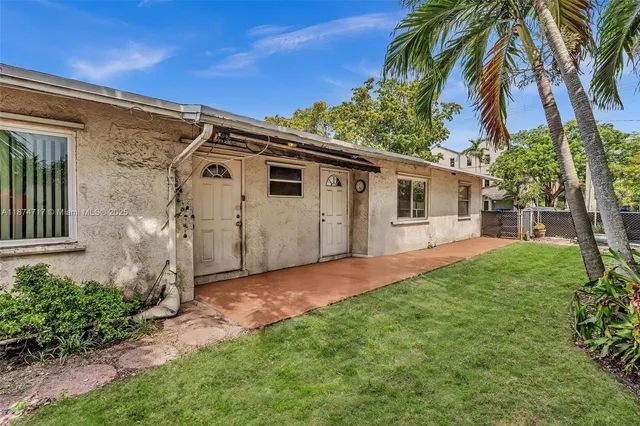 a view of a house with a yard and potted plants