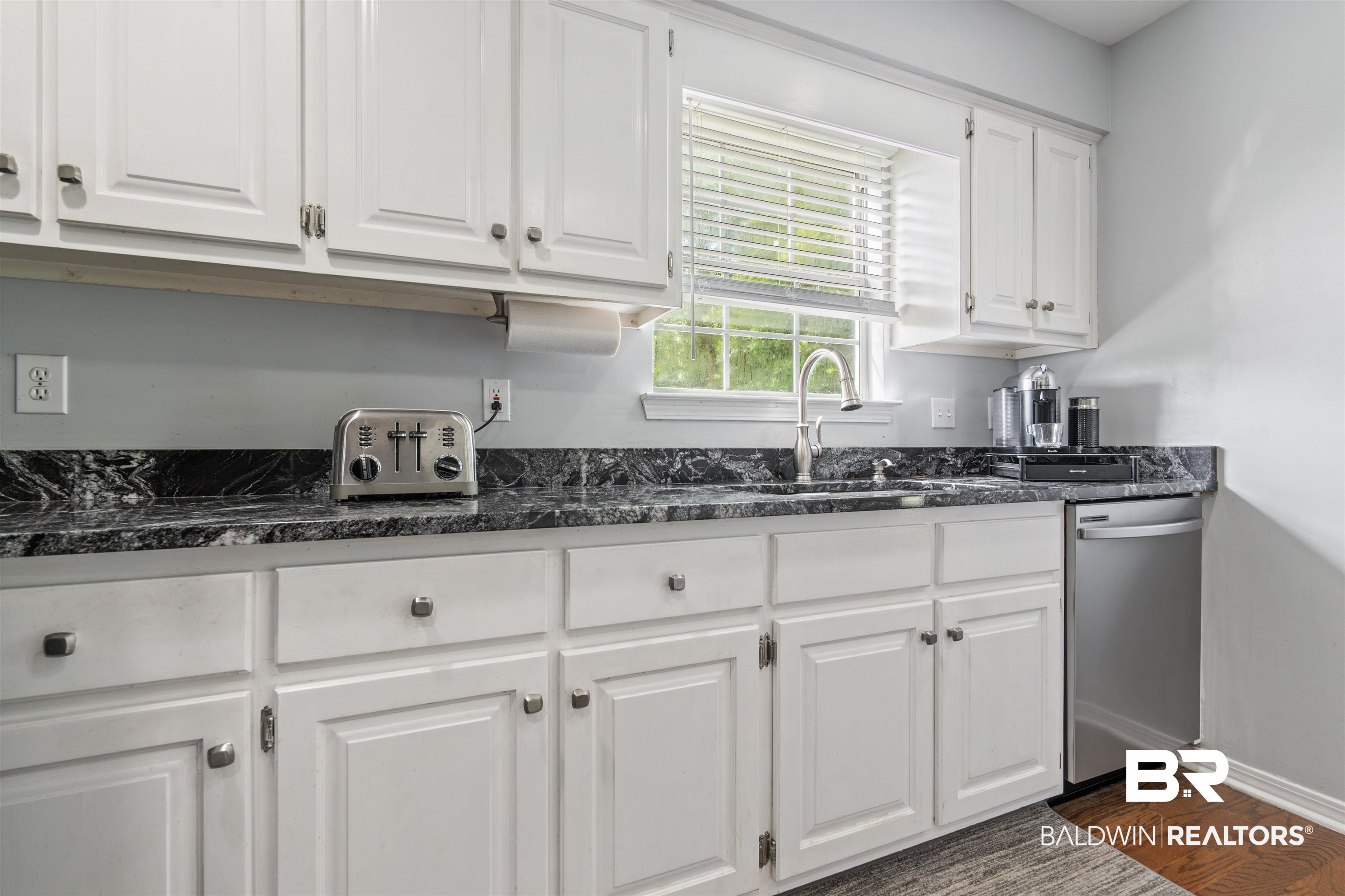 6457 Double Tree Court Mobile, AL 36695 - Photo 9 of 37 Kitchen with dark hardwood / wood-style floors, stainless steel dishwasher, dark stone counters, and white cabinetry