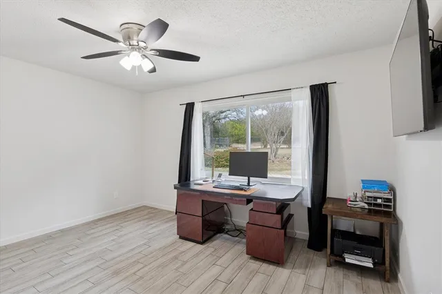 a view of a workspace with furniture and a window