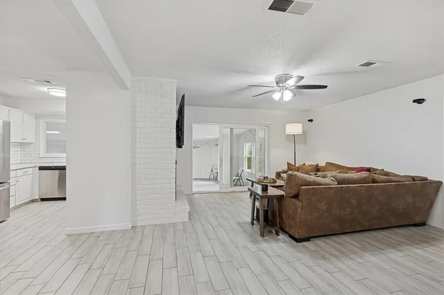 a living room with furniture and a ceiling fan
