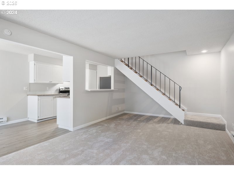 2921 Northeast Rene Avenue, Unit 15B Gresham, OR 97030 - Photo 7 of 22 a view of an empty room with kitchen and stairs