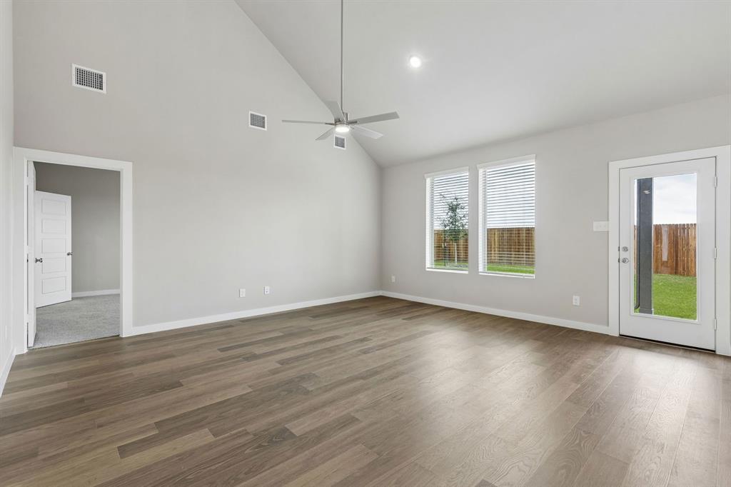 1121 Del Rio Drive Lavon, TX 75166 - Photo 8 of 32 an empty room with wooden floor cabinet and windows