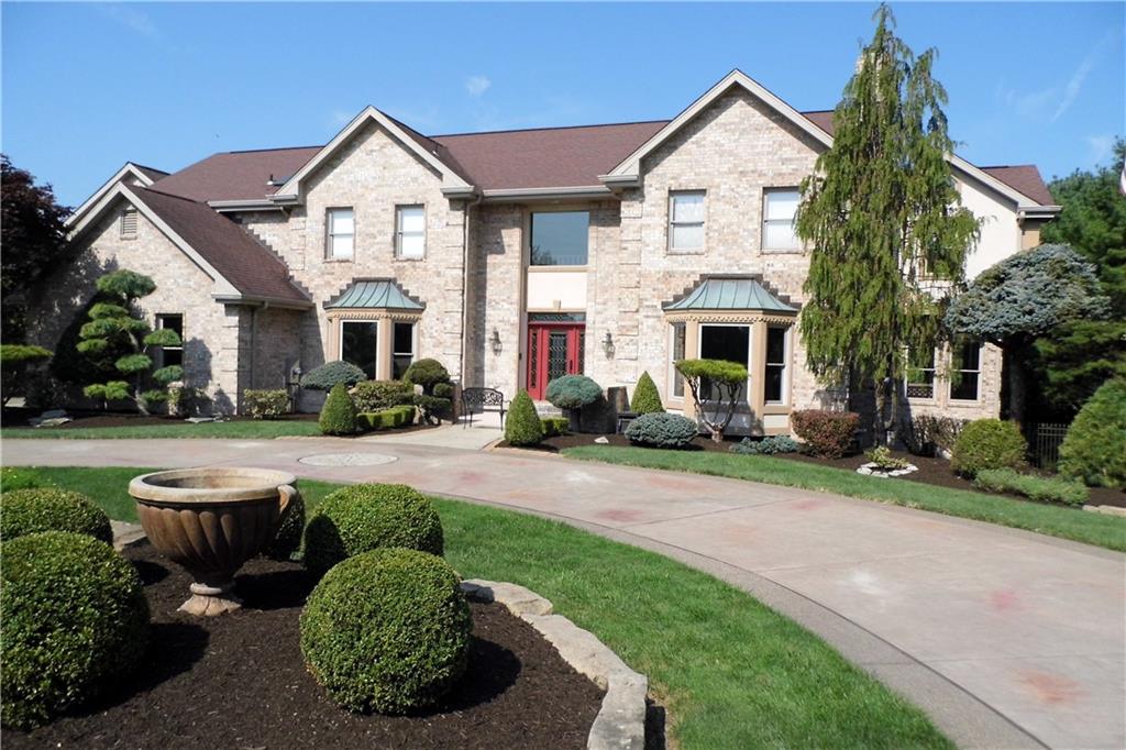 a front view of a house with a yard and potted plants