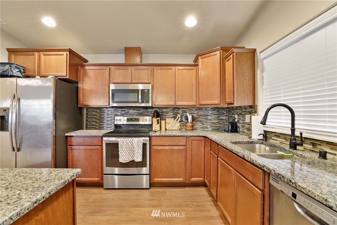 9327 179th Way Southwest Rochester, WA 98579 - Photo 5 of 20 a kitchen with stainless steel appliances granite countertop a sink a stove and refrigerator