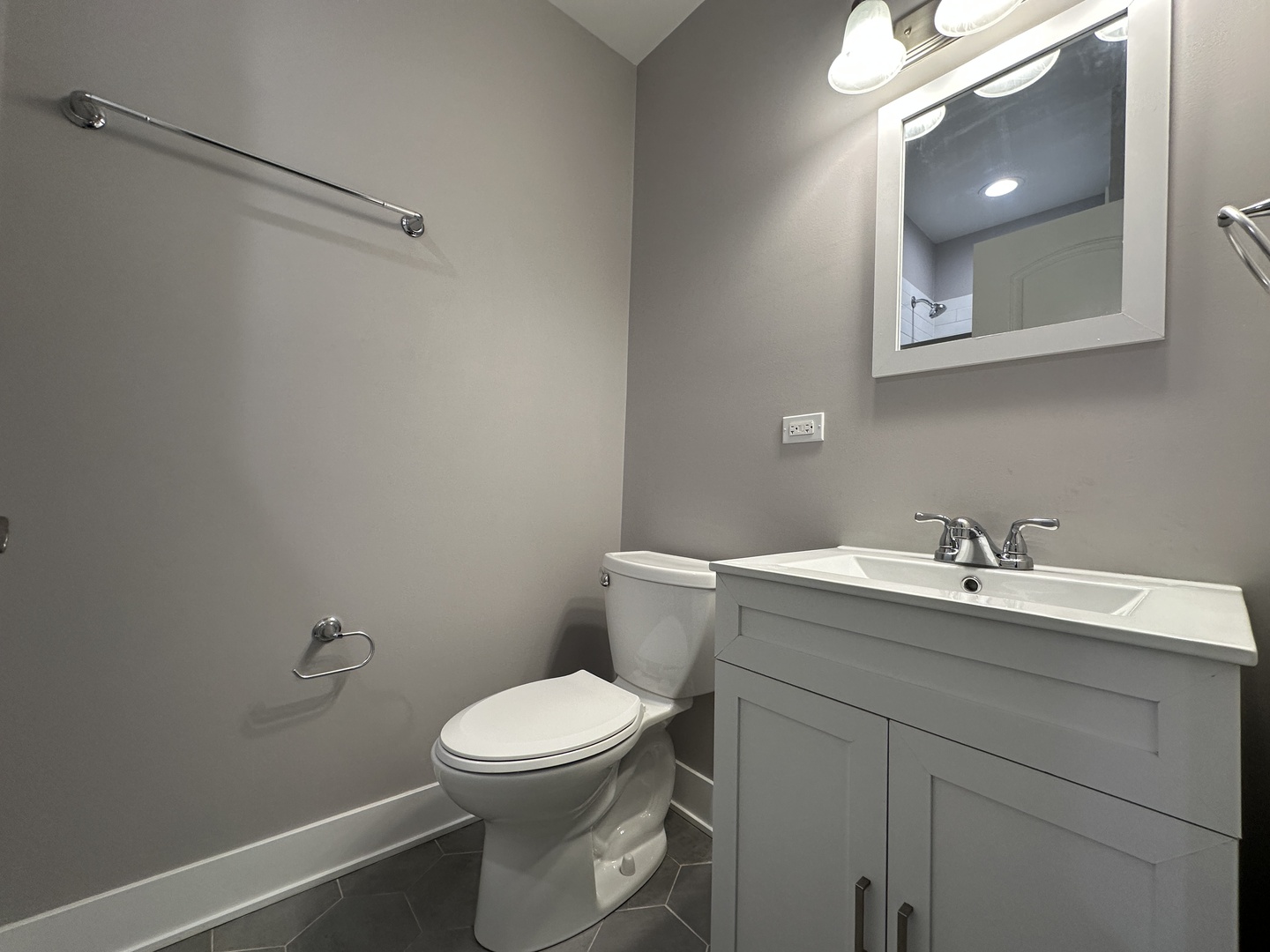 2053 West Iowa Street, Unit 1 Chicago, IL 60622 - Photo 12 of 12 a bathroom with a toilet sink vanity and mirror