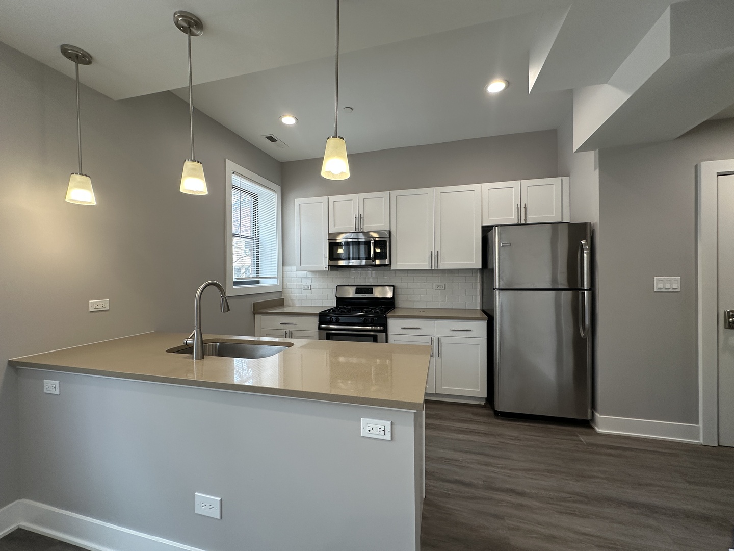 2053 West Iowa Street, Unit 1 Chicago, IL 60622 - Photo 2 of 12 a kitchen with kitchen island a refrigerator a stove a sink and a microwave