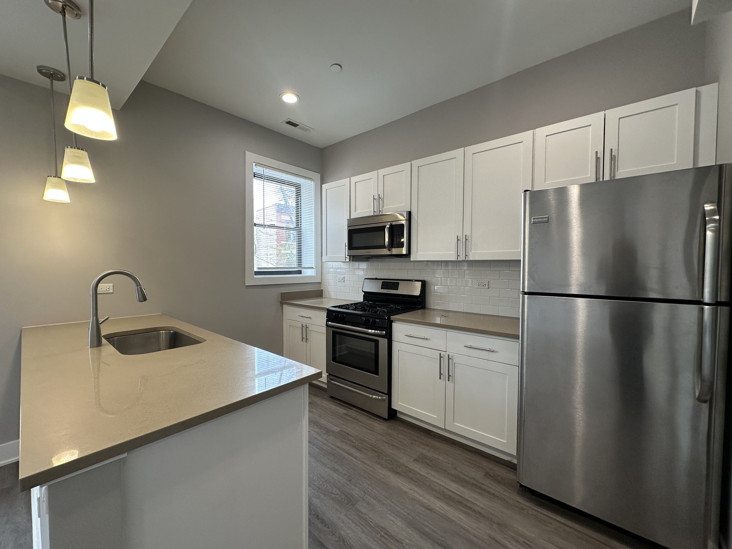 2053 West Iowa Street, Unit 1 Chicago, IL 60622 - Photo 5 of 12 a kitchen with appliances a sink cabinets and a window