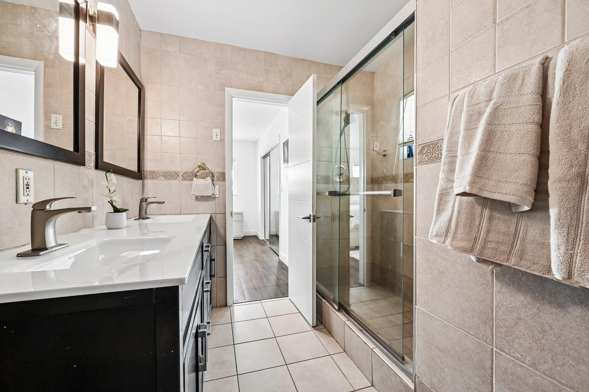 2940 Northeast 39th Court Lighthouse Point, FL 33064 - Photo 21 of 42 a bathroom with a shower sink and mirror