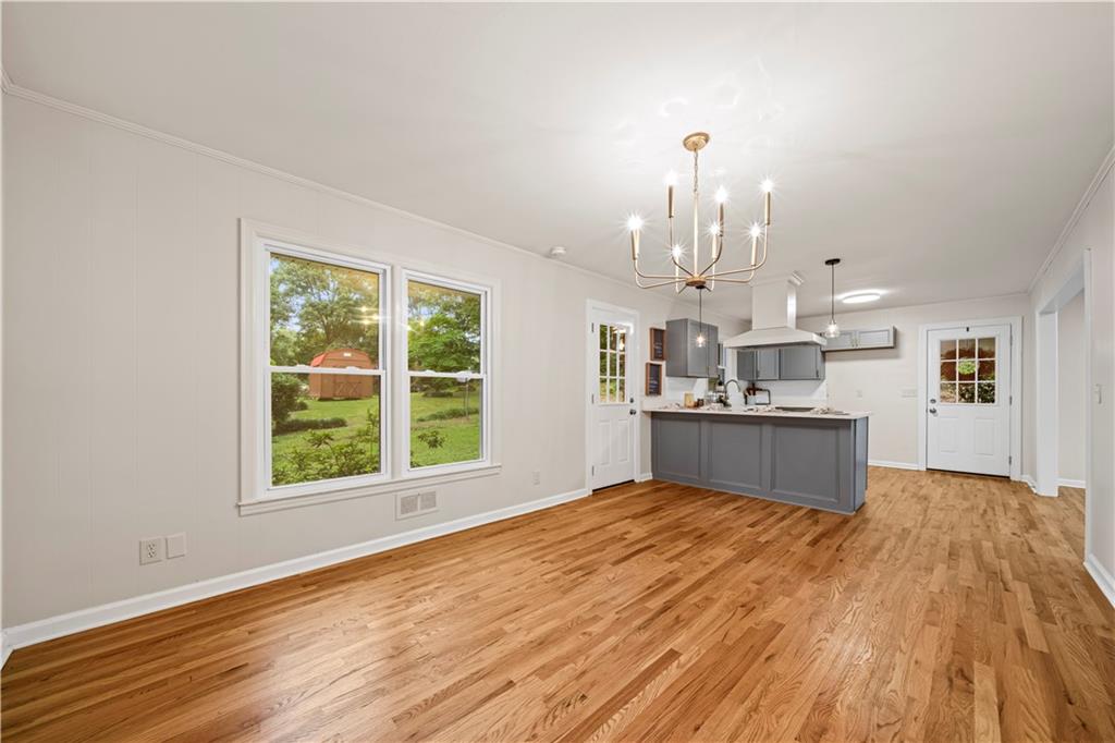 23 East Camelia Road Northeast Rome, GA 30161 - Photo 8 of 27 a view of a kitchen with kitchen island a sink wooden floor and a large window
