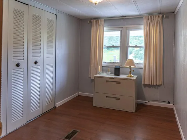 a room with a window and a dresser