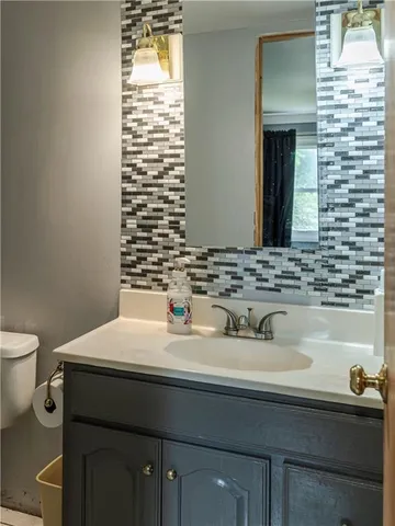 a bathroom with a sink a toilet and mirror
