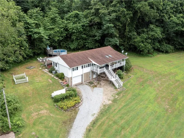 an aerial view of a house with yard swimming pool and outdoor seating