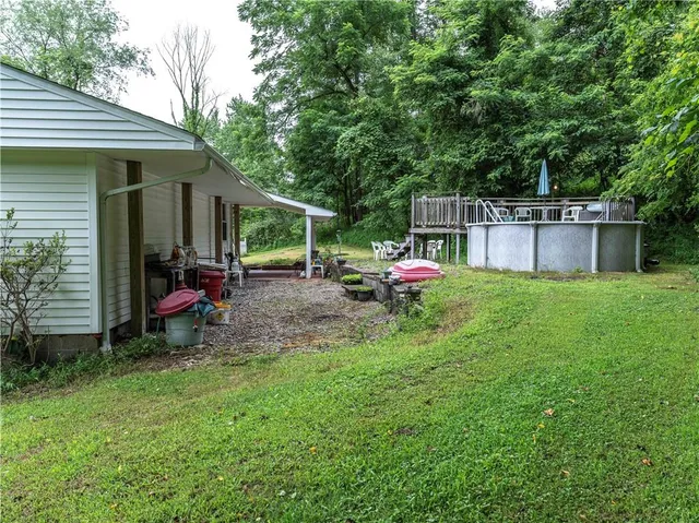 a view of two chairs and table in a backyard