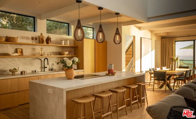 a kitchen with a sink a stove and chairs