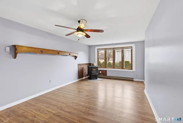 a view of n empty room with window and wooden floor