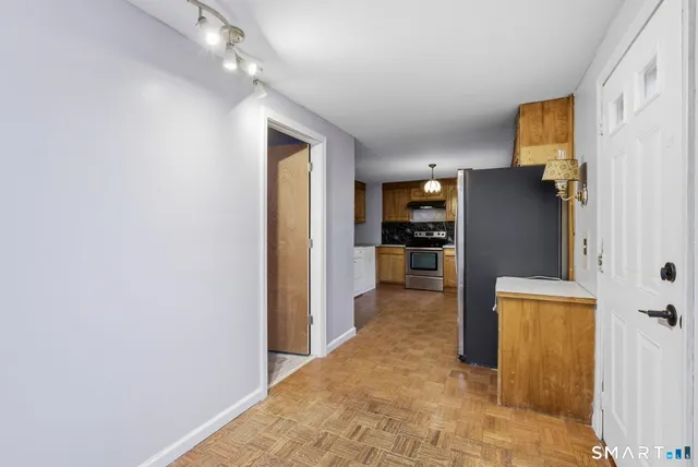 a view of a kitchen with a refrigerator and a stove top oven