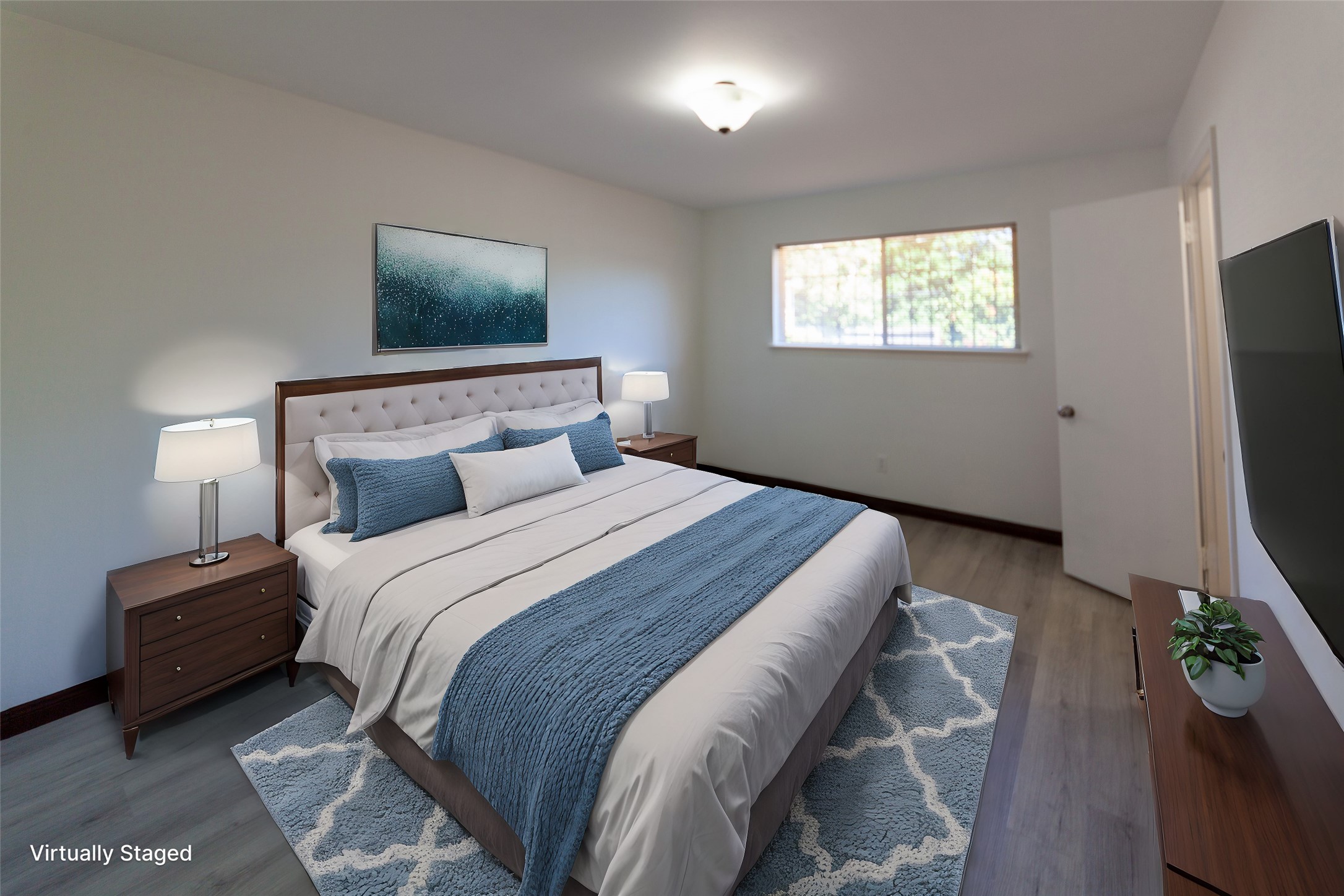 8826 Roos Road Houston, TX 77036 - Photo 28 of 42 This virtually staged bedroom 4 features a cozy layout with hardwood flooring, a large window for natural light, and modern furnishings including a bed, nightstands, and a wall-mounted TV.