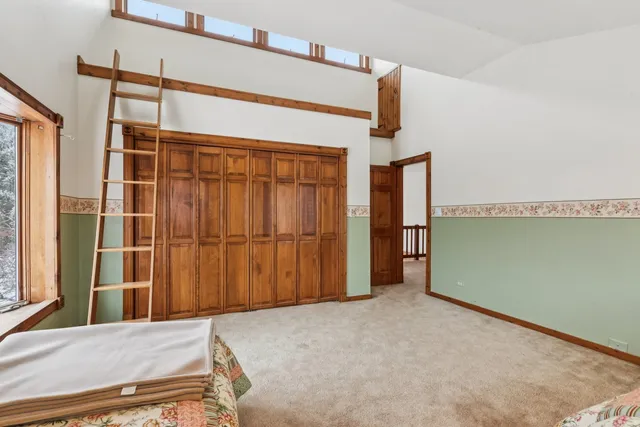 a view of an empty room with wooden floor and windows