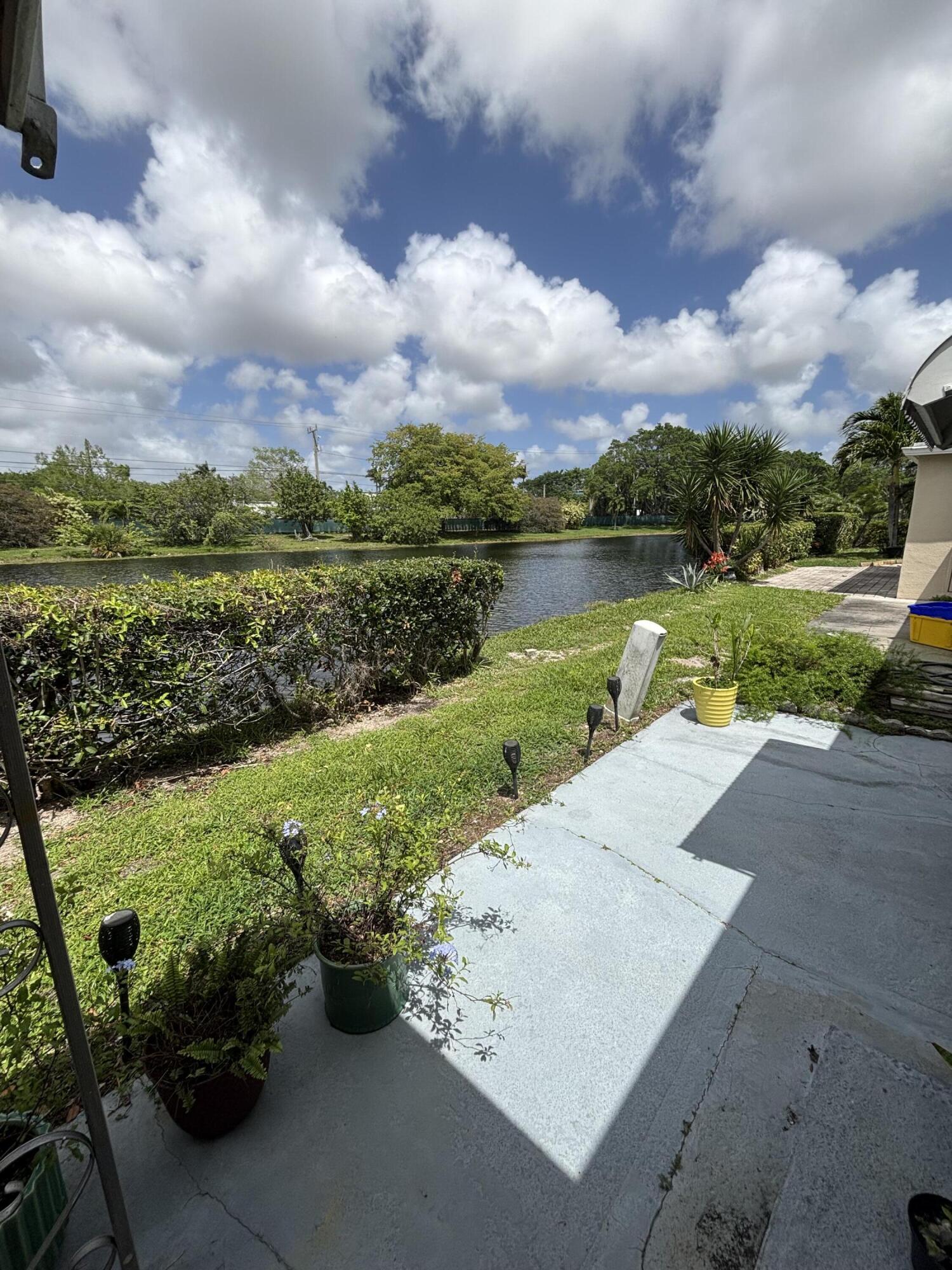 8833 Bella Vista Drive, Unit 8833 Boca Raton, FL 33433 - Photo 18 of 47 a view of a lake with a yard