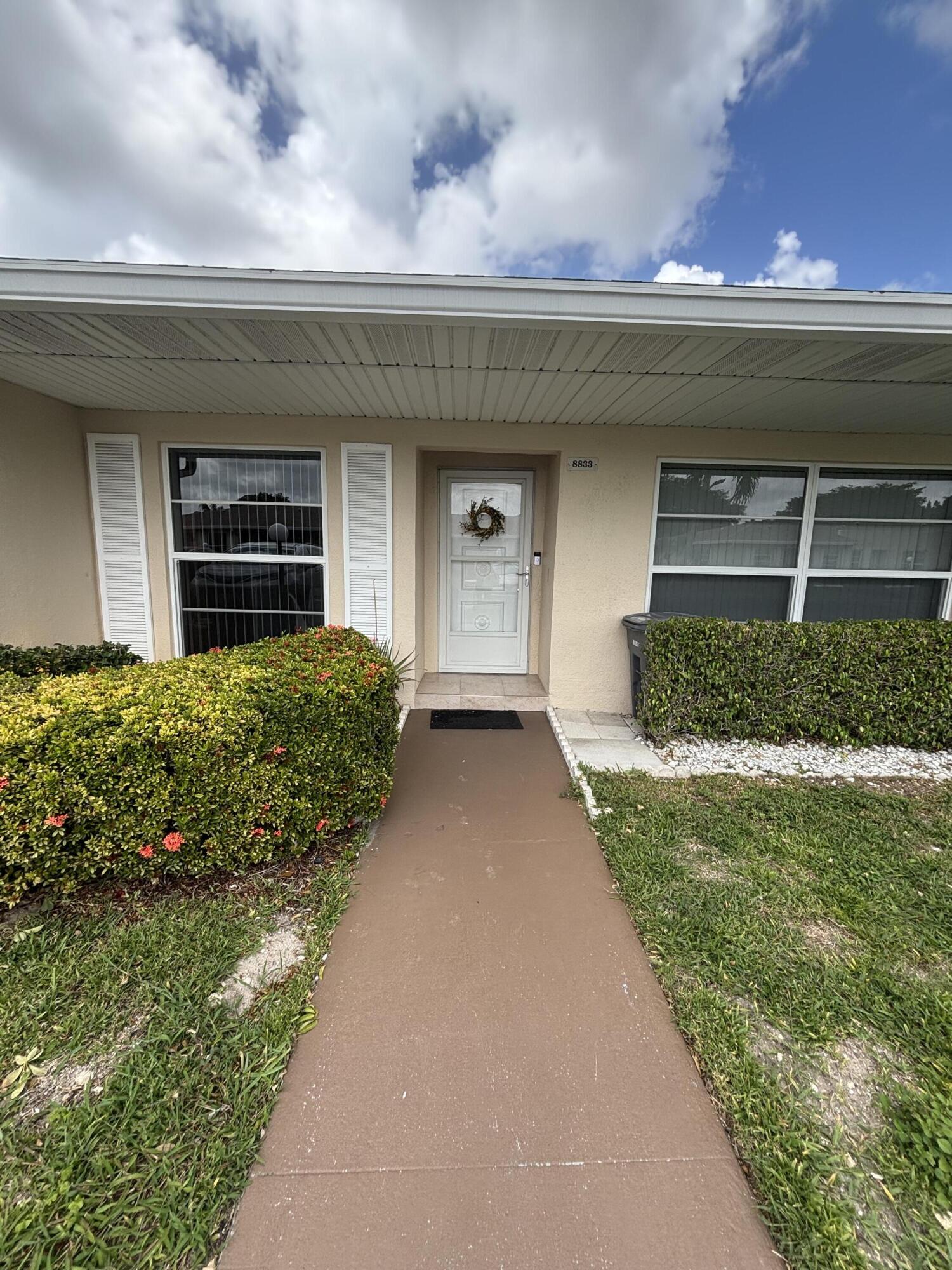 8833 Bella Vista Drive, Unit 8833 Boca Raton, FL 33433 - Photo 3 of 47 a front view of a house with a yard