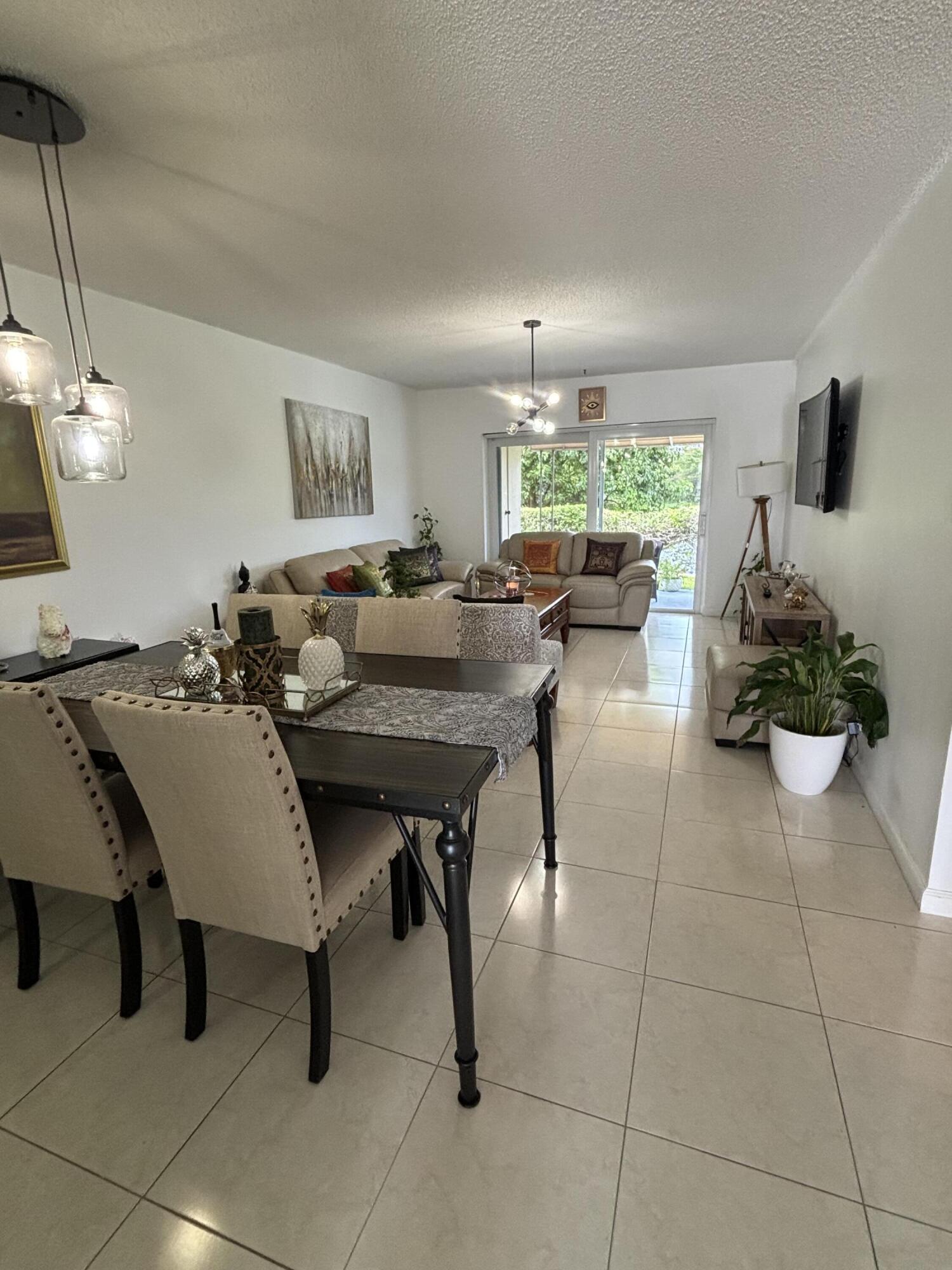8833 Bella Vista Drive, Unit 8833 Boca Raton, FL 33433 - Photo 5 of 47 a view of a dining room with furniture and a large window