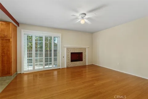 a view of an empty room with a window and fireplace