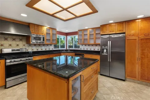 a kitchen with stainless steel appliances granite countertop a sink a stove and a refrigerator