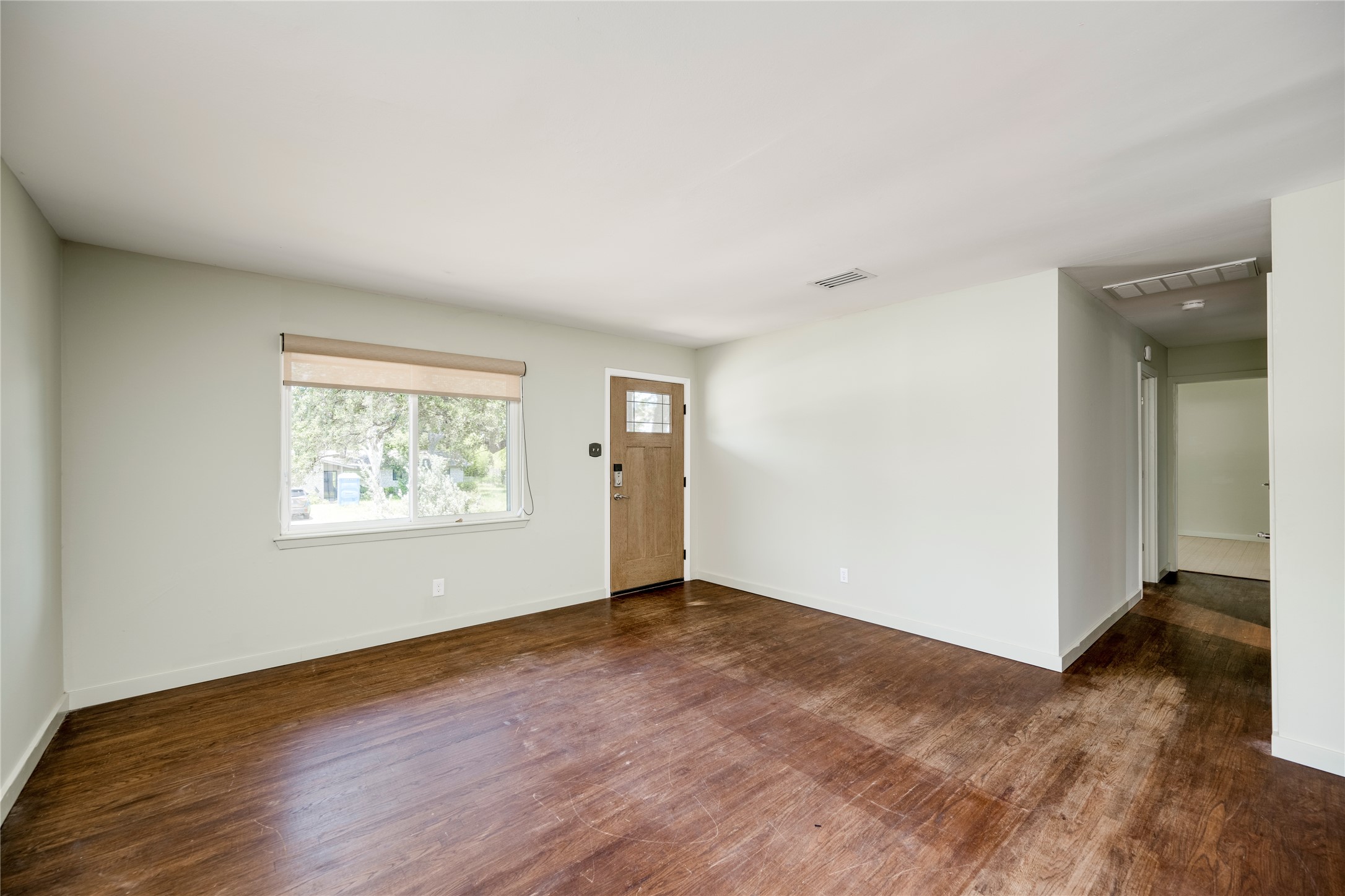 1707 Overhill Drive Austin, TX 78721 - Photo 7 of 36 A well-lit living area features warm wood flooring and direct entry to a welcoming foyer.