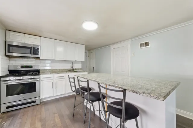 a kitchen with stainless steel appliances granite countertop a stove top oven a sink counter space and cabinets