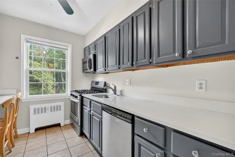 a kitchen with stainless steel appliances granite countertop a sink a stove a washer and dryer