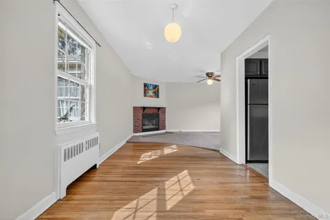 a view of a livingroom with wooden floor and a fireplace