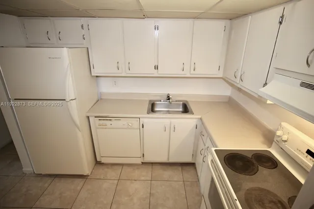 a kitchen with a refrigerator sink and cabinets