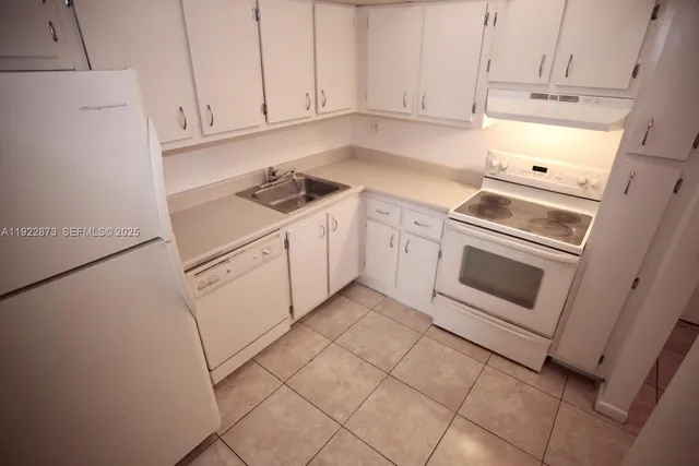 a kitchen with white cabinets and white appliances