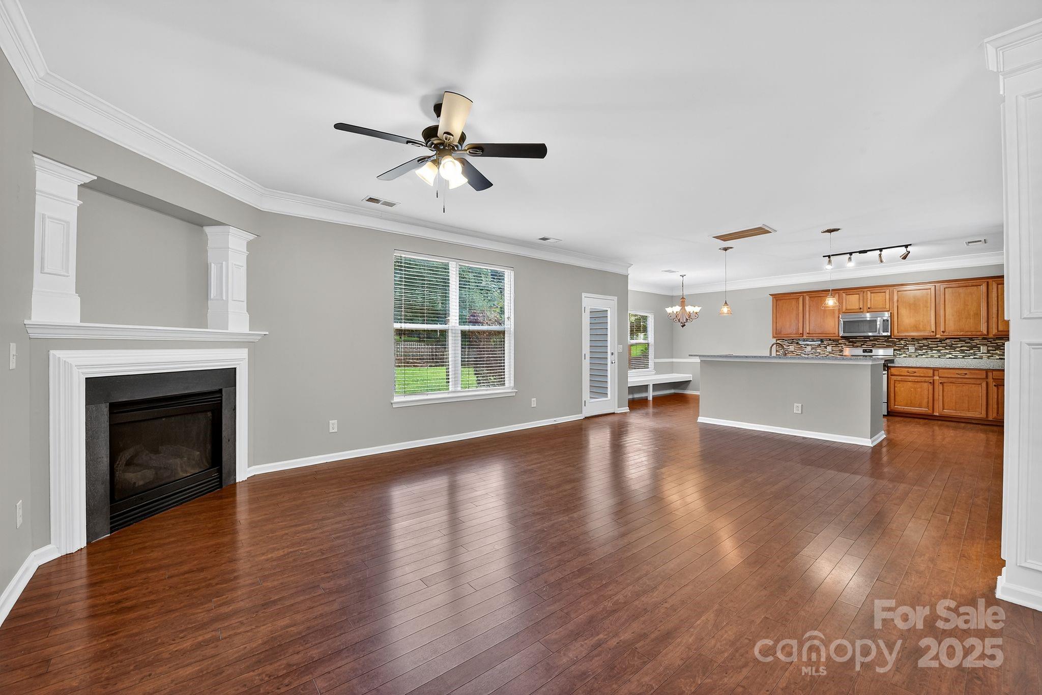 3114 Less Traveled Trail Indian Trail, NC 28079 - Photo 12 of 32 a view of a kitchen with wooden floor and a fireplace
