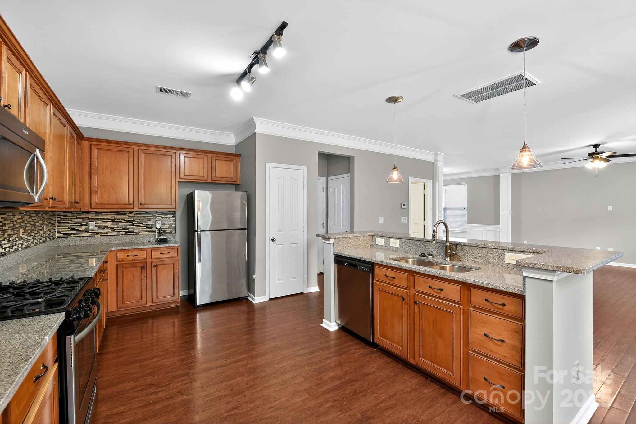 3114 Less Traveled Trail Indian Trail, NC 28079 - Photo 18 of 32 a kitchen with stainless steel appliances granite countertop a sink stove and refrigerator