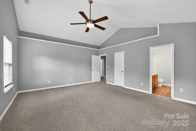 an empty room with a ceiling fan and a window