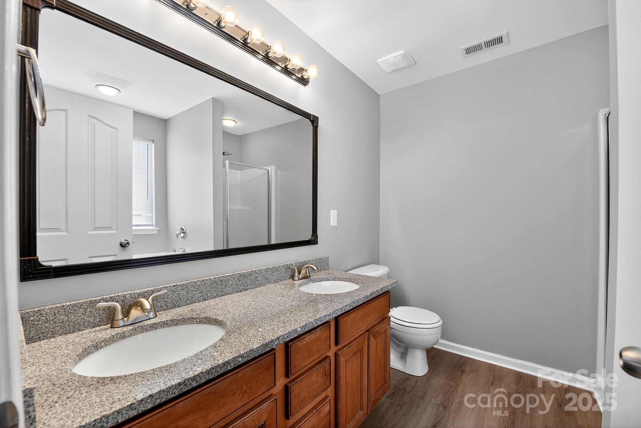 3114 Less Traveled Trail Indian Trail, NC 28079 - Photo 25 of 32 a bathroom with a granite countertop sink a toilet and a mirror