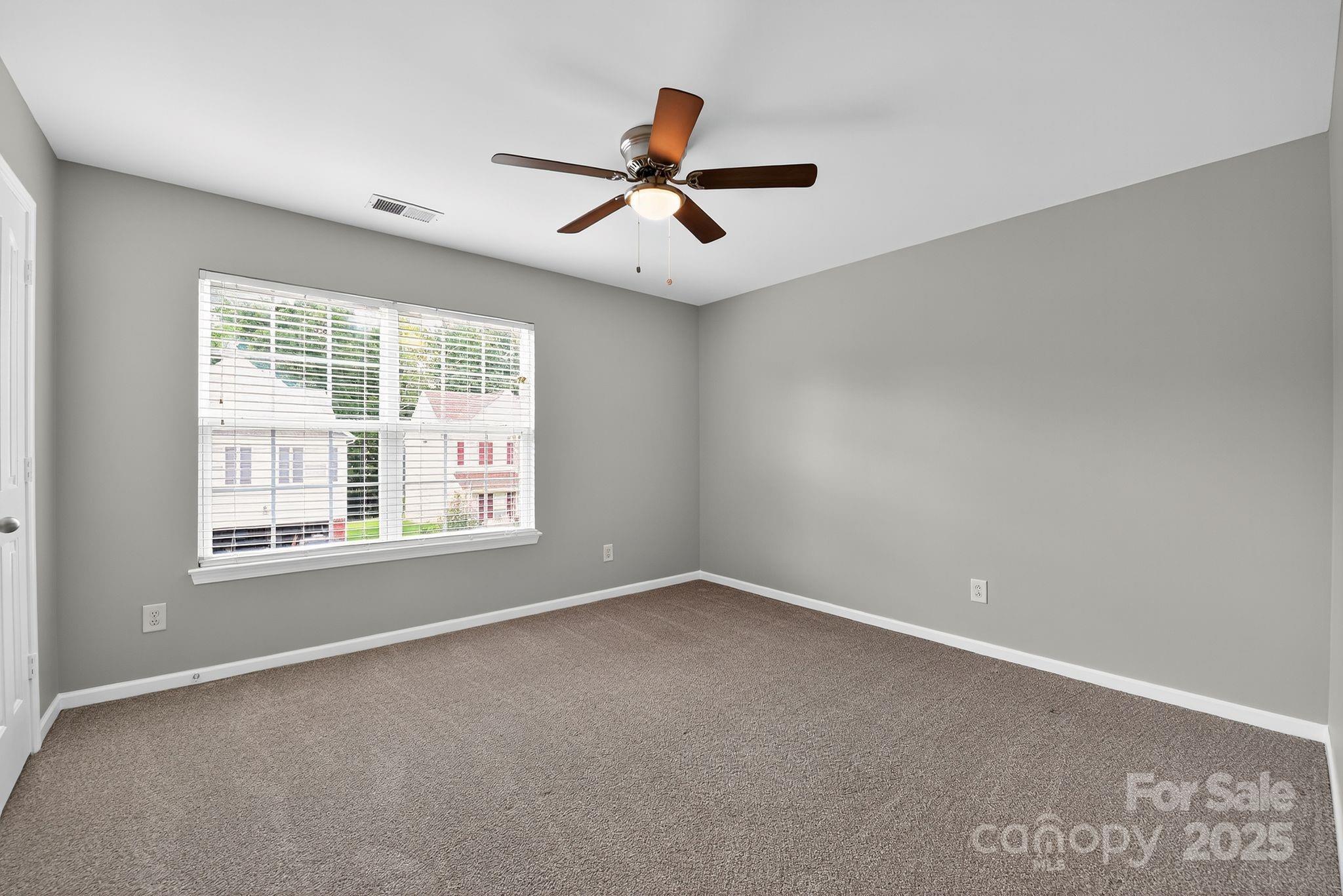 3114 Less Traveled Trail Indian Trail, NC 28079 - Photo 26 of 32 an empty room with ceiling fan and windows