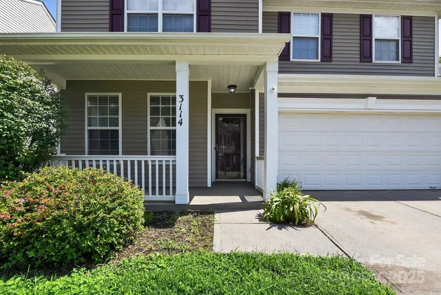 a front view of a house with a lots of flower plants