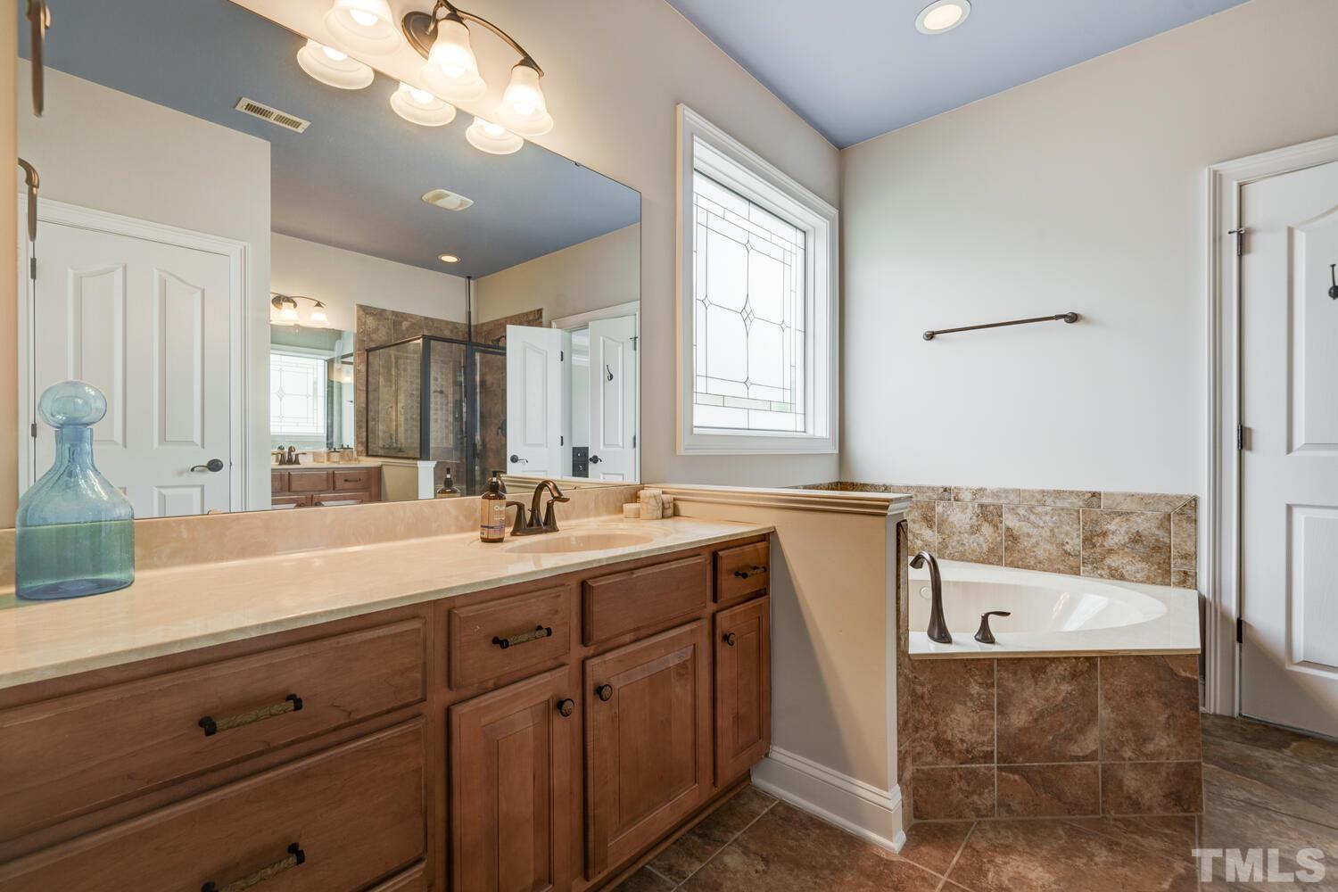3907 Morvan Way Raleigh, NC 27612 - Photo 34 of 69 a bathroom with a tub a sink and mirror