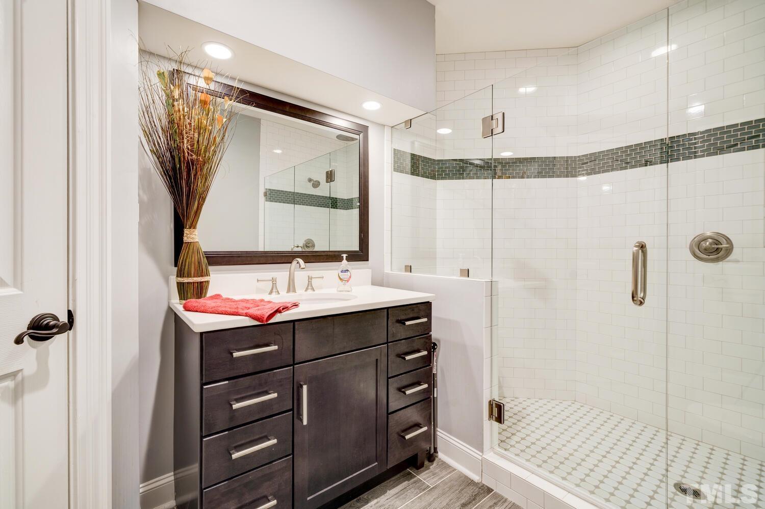 3907 Morvan Way Raleigh, NC 27612 - Photo 50 of 69 a bathroom with a sink mirror and a shower