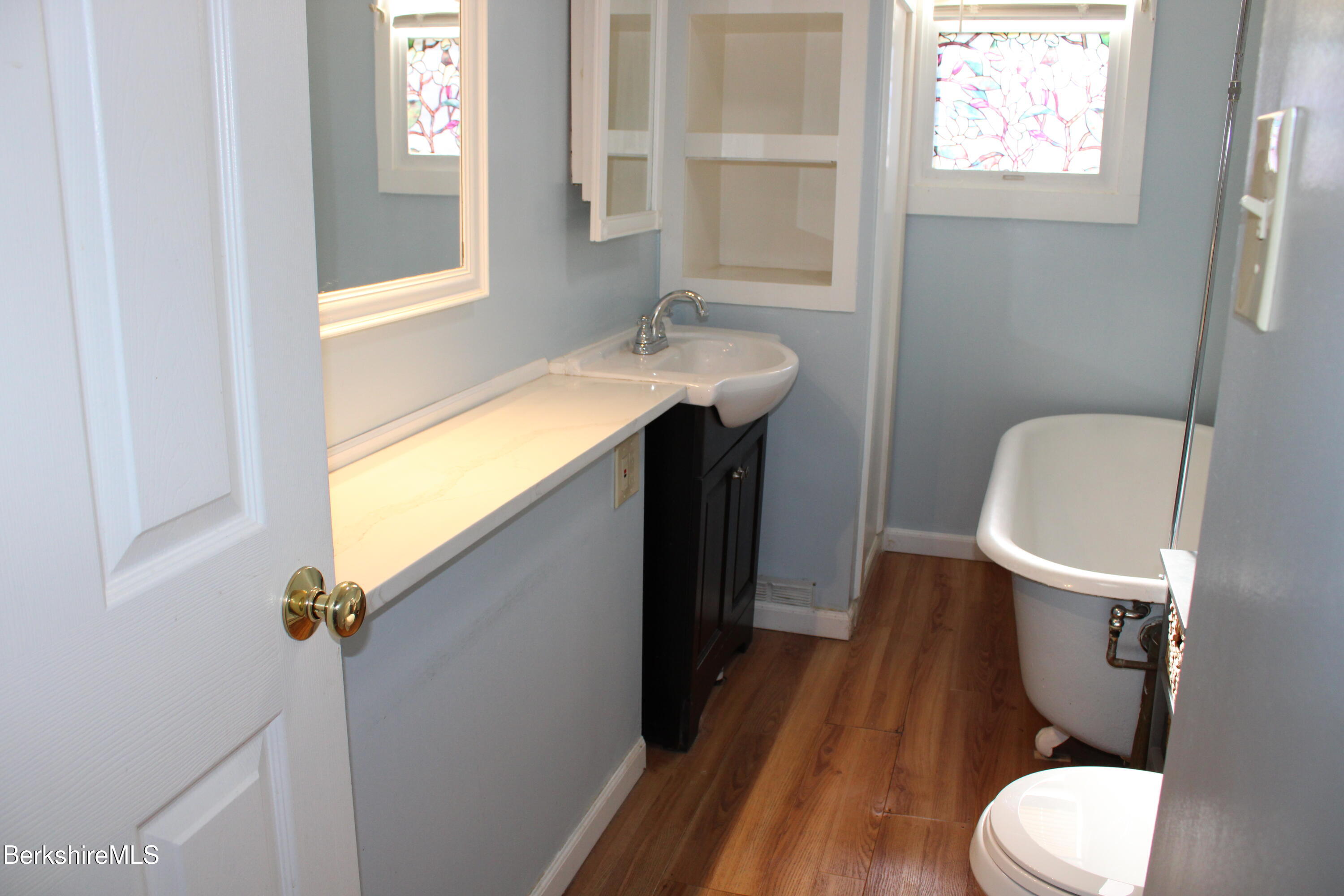 3-5 Pleasant Street Pittsfield, MA 01201 - Photo 15 of 40 a bathroom with a sink a toilet a mirror and window