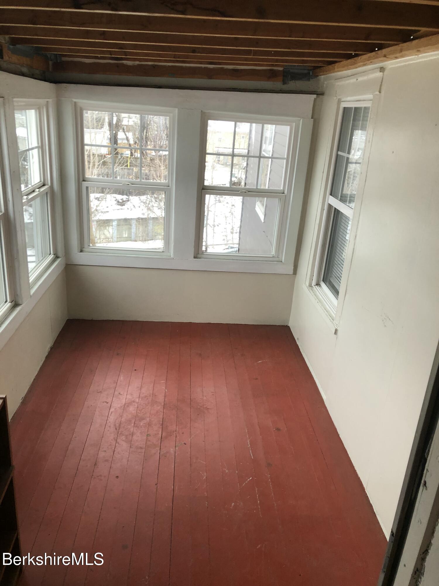 3-5 Pleasant Street Pittsfield, MA 01201 - Photo 26 of 40 an empty room with wooden floor and windows