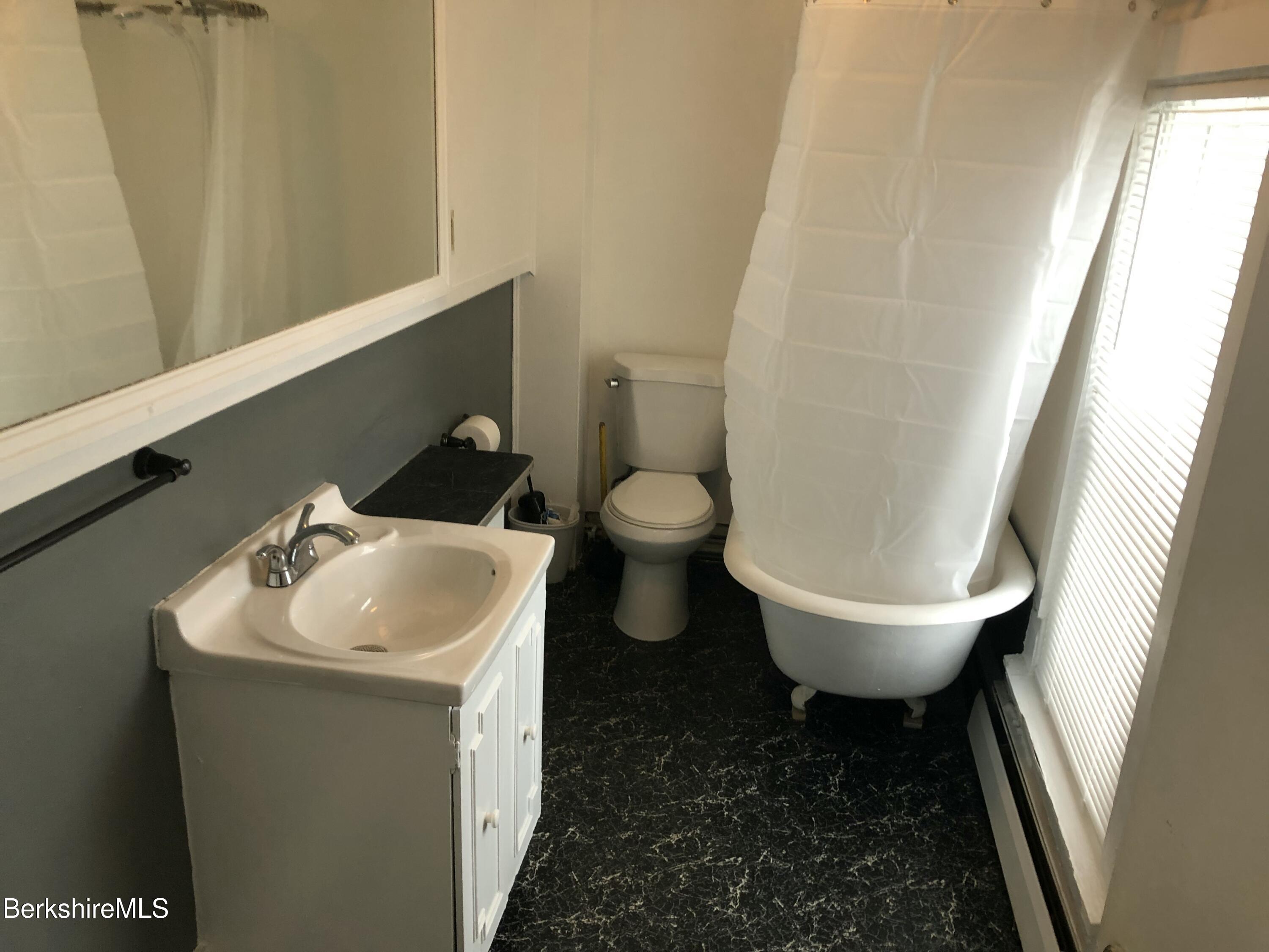 3-5 Pleasant Street Pittsfield, MA 01201 - Photo 31 of 40 a bathroom with a toilet sink and mirror
