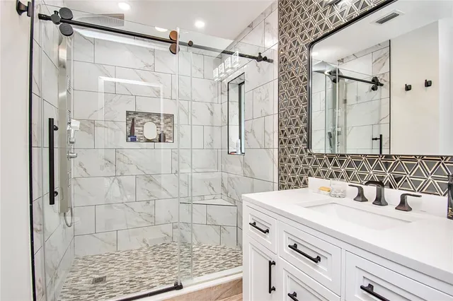 a bathroom with a sink shower and a mirror