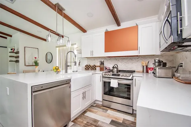 a kitchen with stainless steel appliances granite countertop a sink and cabinets
